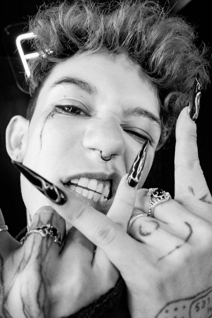 Dynamic black and white portrait featuring an edgy look with unique nails and rings.